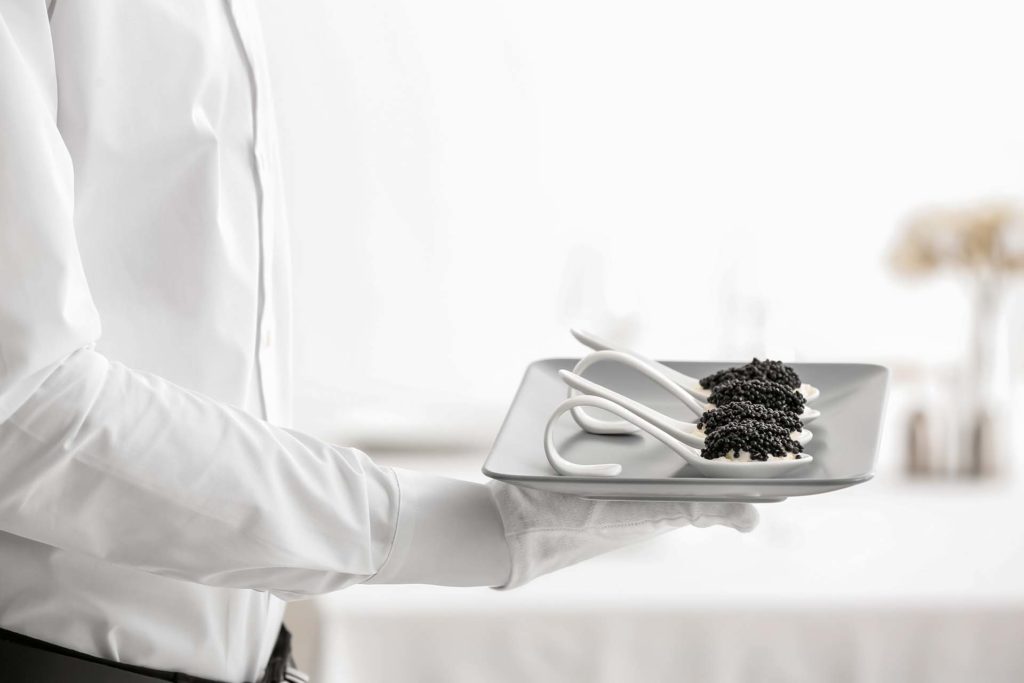 A person holding a plate with caviar