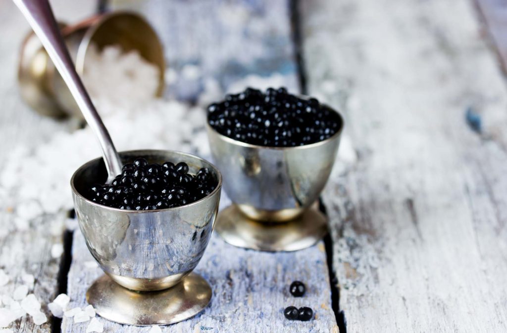 Caviar in metallic bowls with spoons

