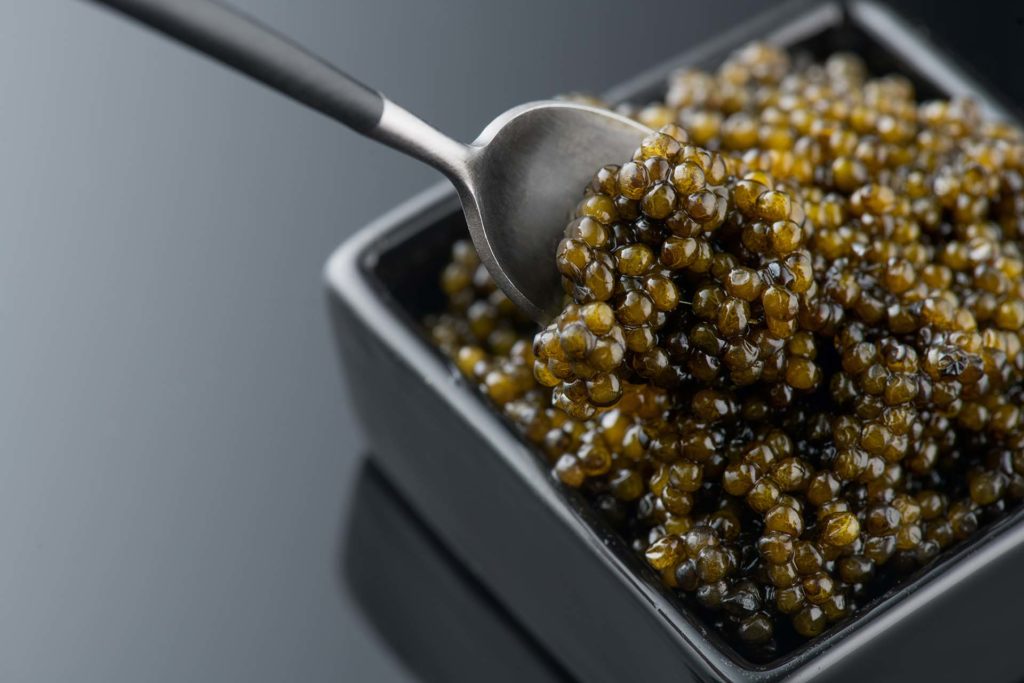 Spoon placed in a bowl of caviar