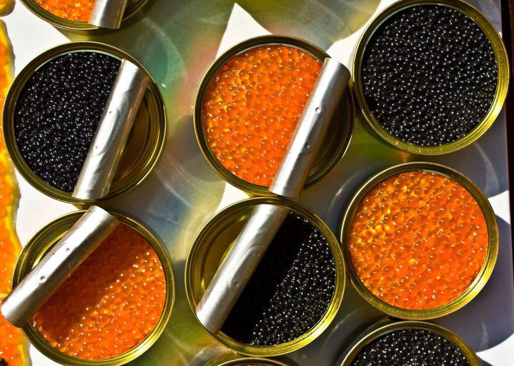 Tins (cans) with red and black caviar, opened.